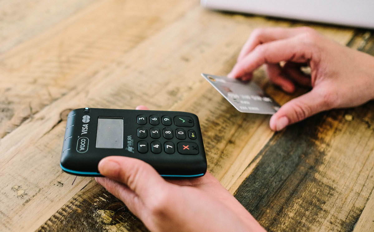 A Yoco card machine on a wooden table.