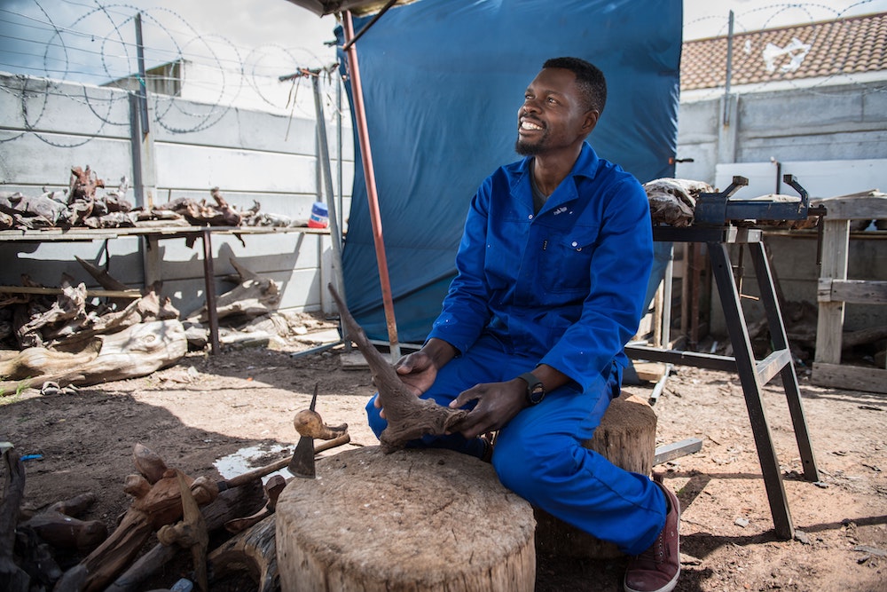 Boniface working in the Unique Driftwood Creations workshop.