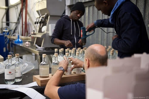 Preparing the gin bottles for labelling and packaging.