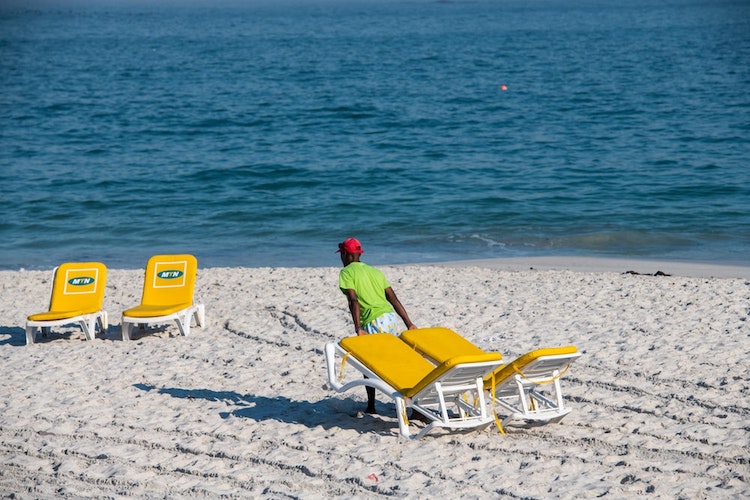 Pulling chairs on a Cape Town beach.