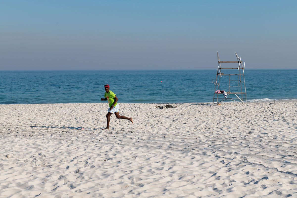 A vendor running across a Cape Town beach.