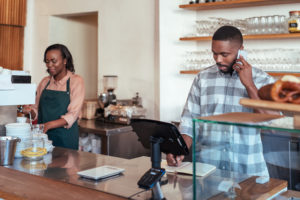 A business owner working alongside his employee.