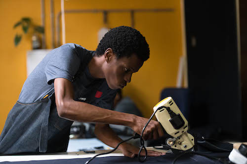 Pressing the joints of jeans made at Tshepo the Jean Maker.