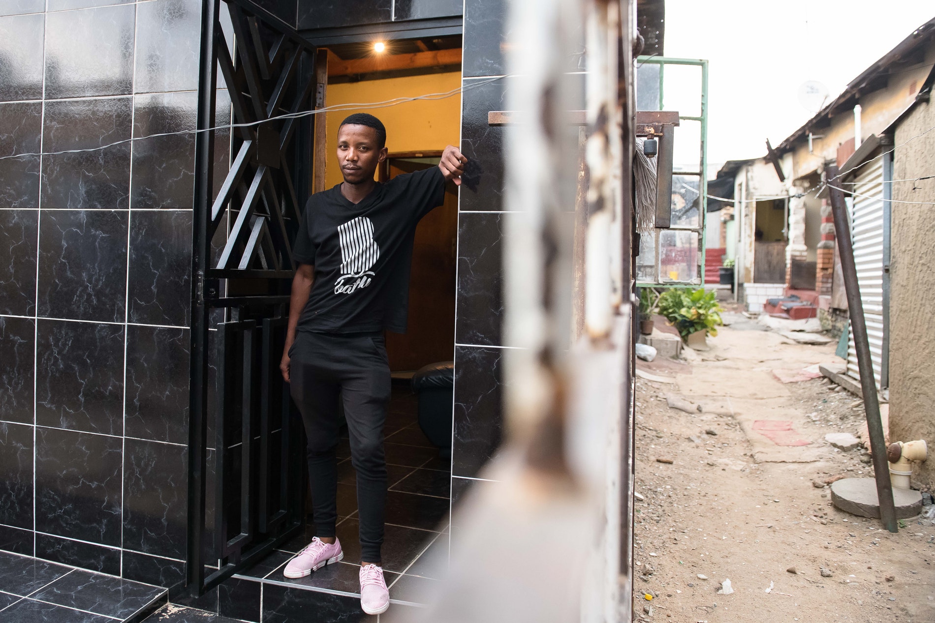 A man standing outside the house where Theo Baloyi started Bathu shoes.