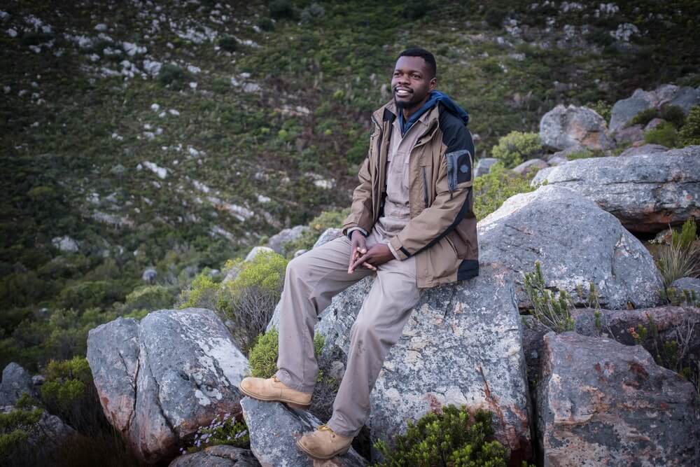 Boniface posing for a portrait on a boulder.