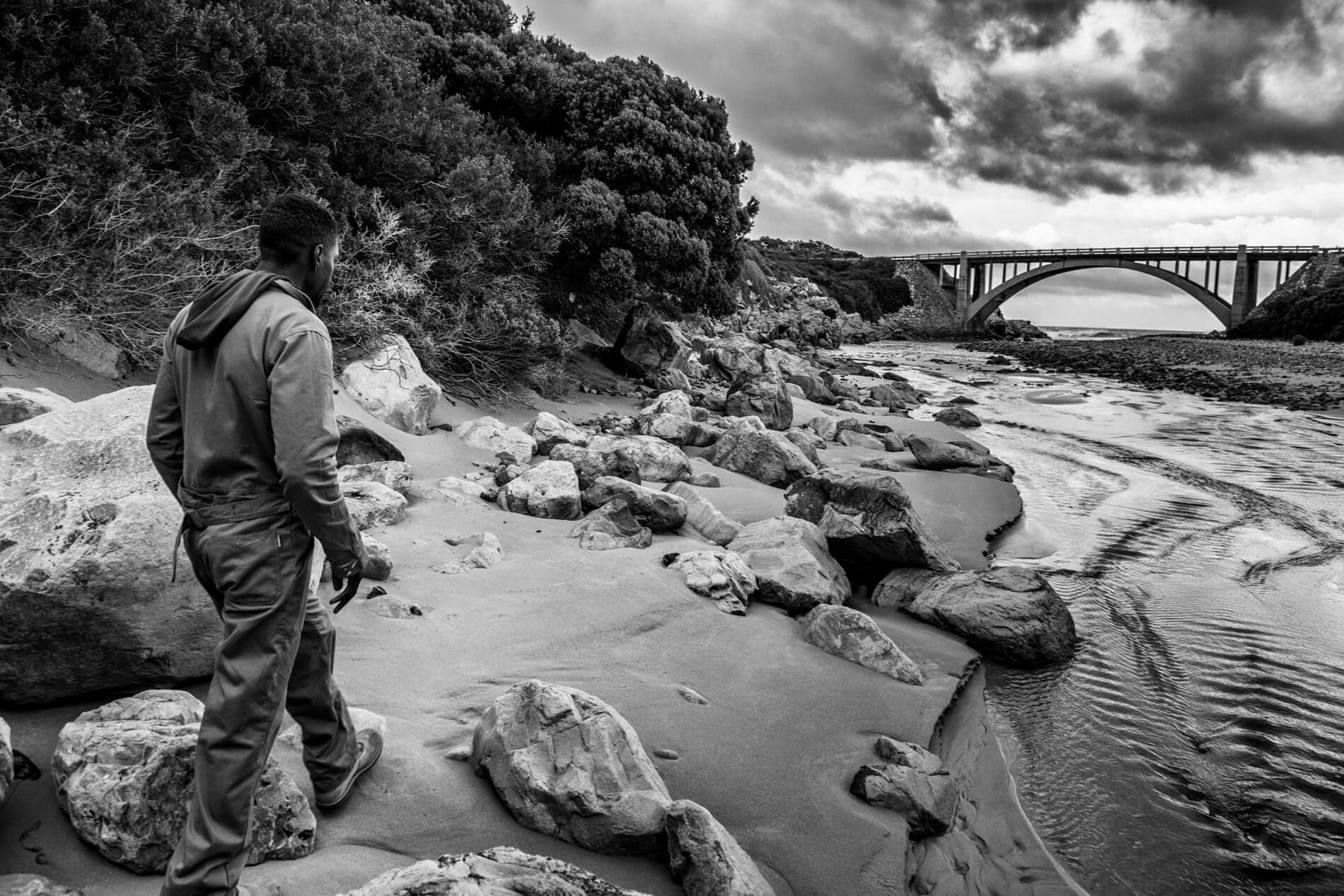 Walking along the riverbank looking for wood.