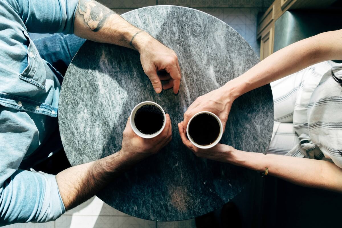 Two people have a cup of coffee in a business mentor meeting.