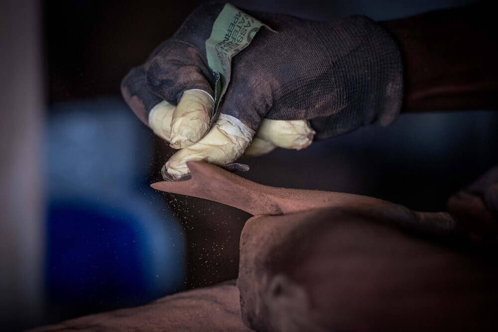 Sanding the edges of the wood.