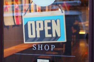 An image of a store open sign in an article about opening a retail store.