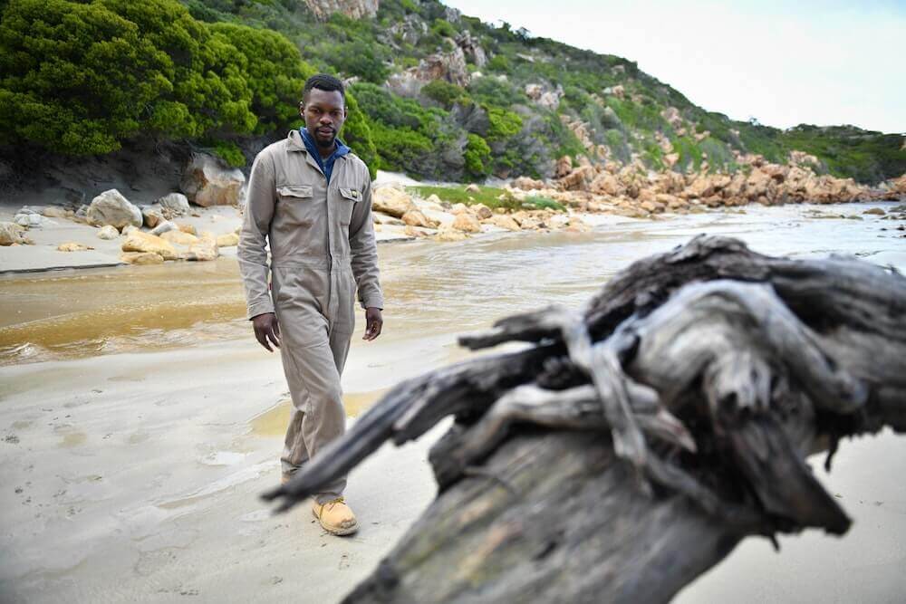 A piece of wood foregrounding an image of Boniface.